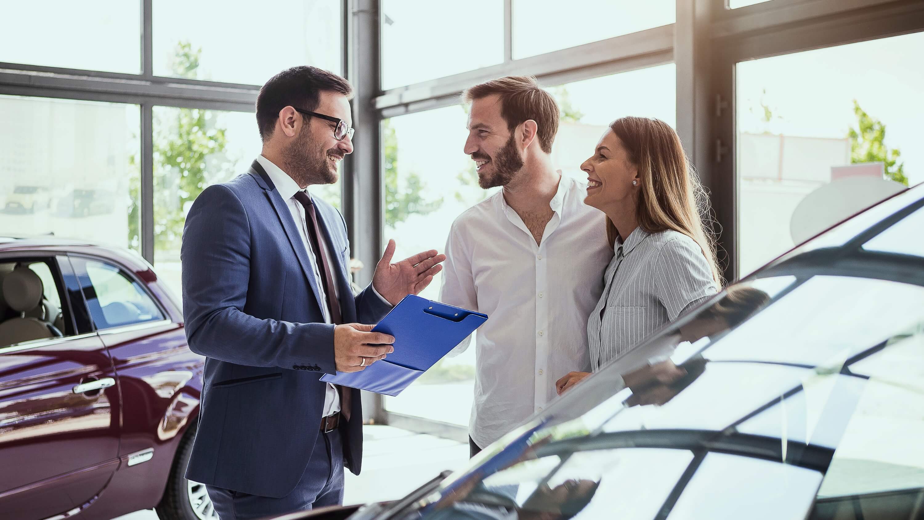 Multi-store dealer group SEO standards — sales manager closing a deal on the showroom floor
